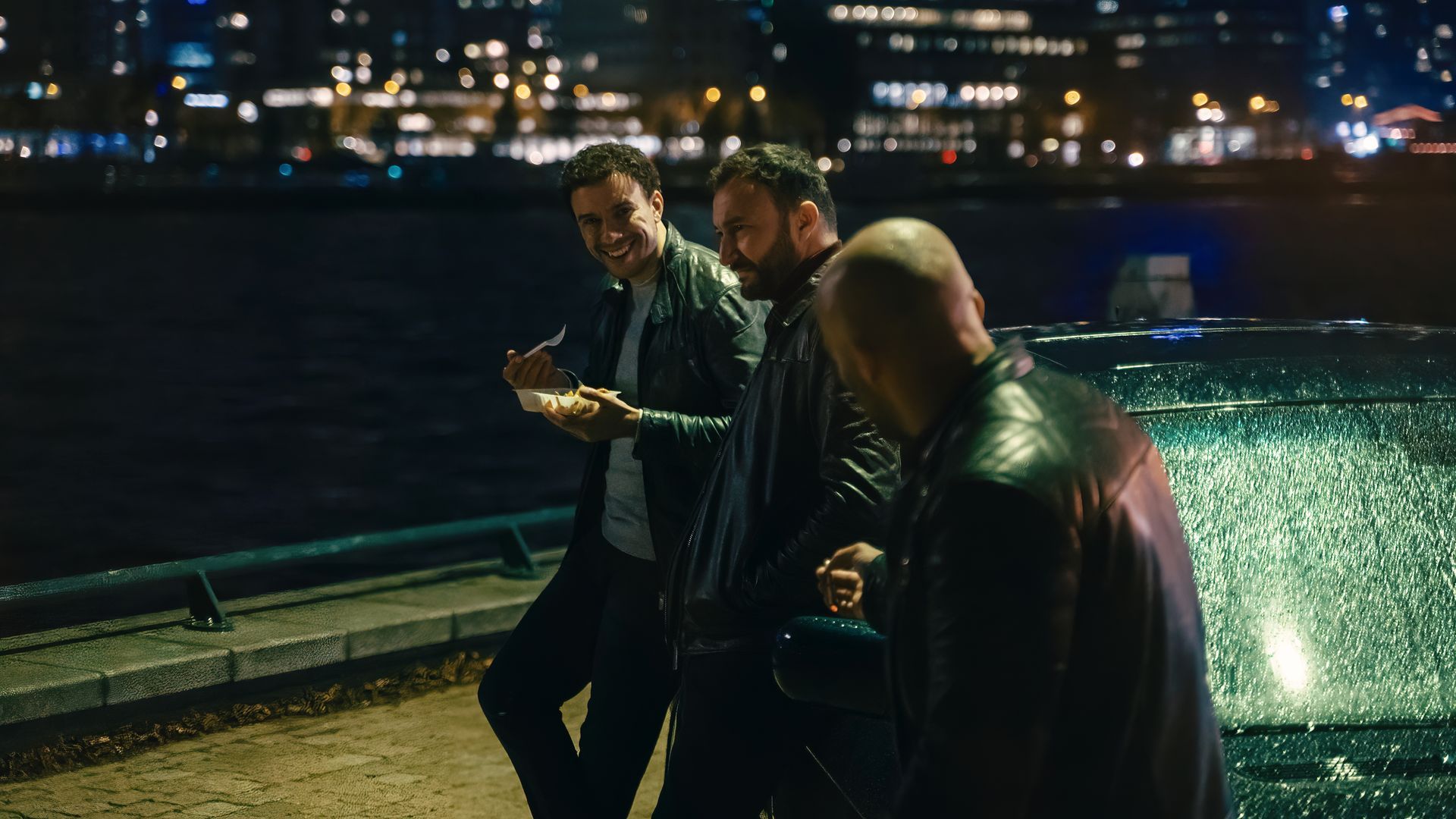 Eine Gruppe von Männern steht nachts neben einem Gewässer