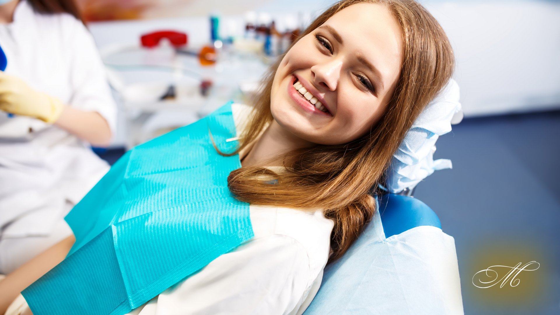 A woman is smiling while sitting in a dental chair.