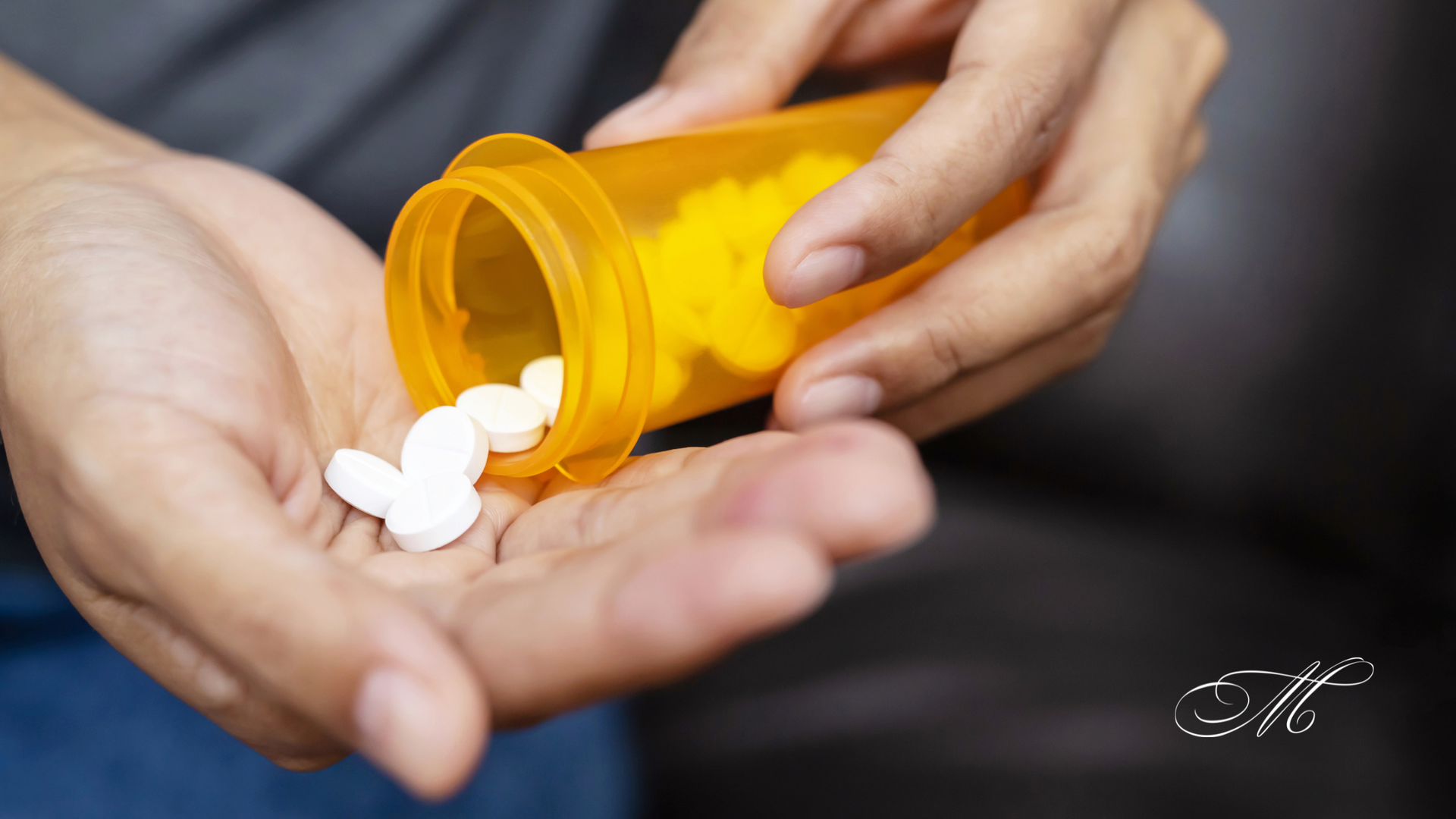 A person is pouring pills from a bottle into their hand