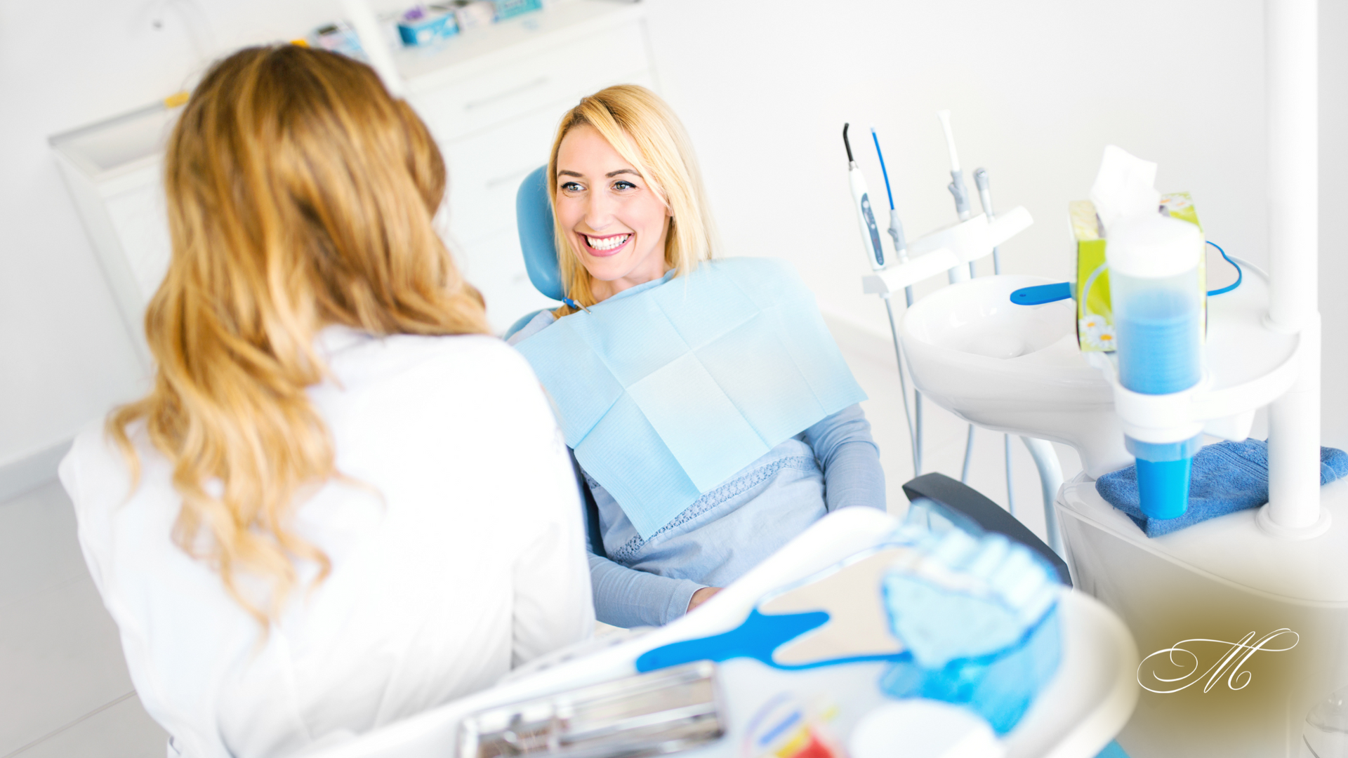 Dentist examining patient's teeth in a brightly lit dental office.