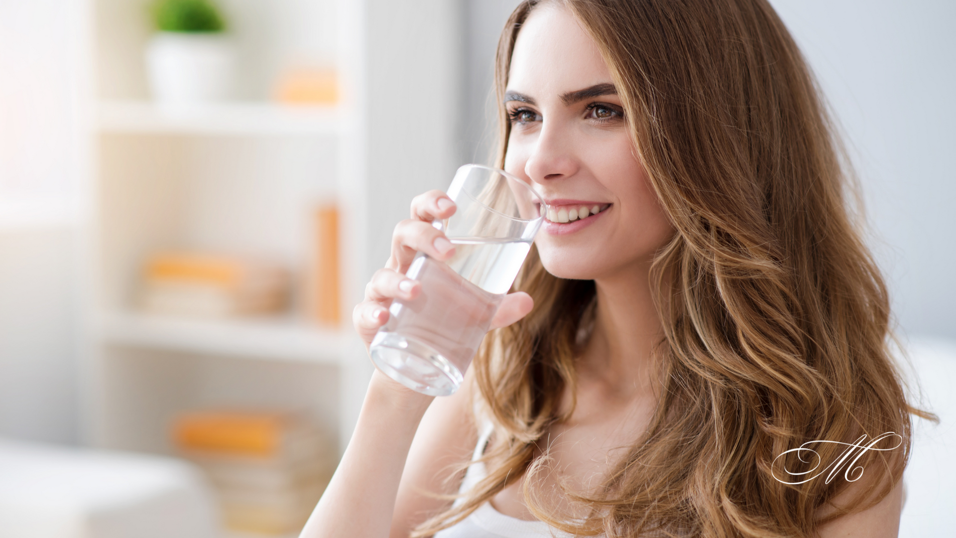 A woman is drinking a glass of water.