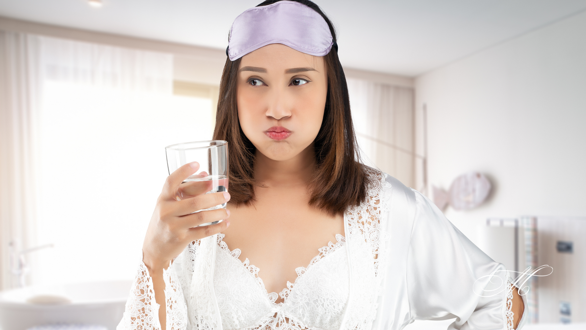 A woman wearing a sleep mask is drinking a glass of water.