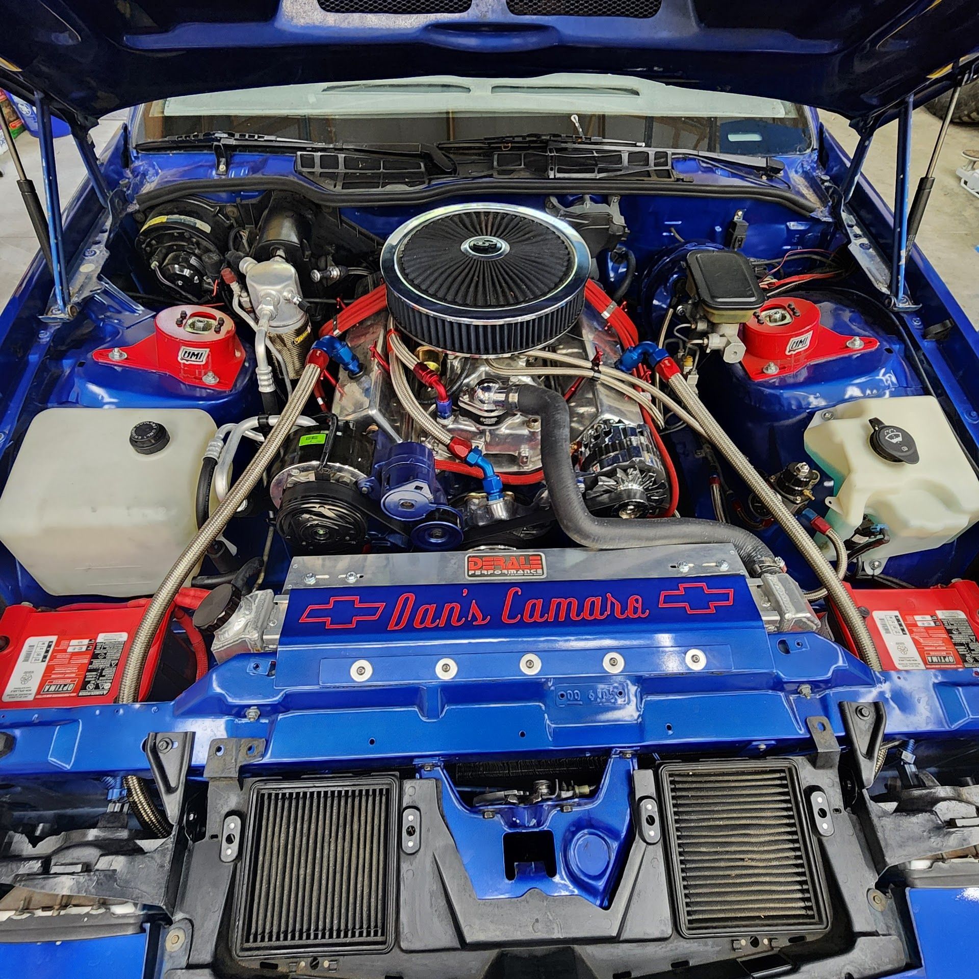 Blue custom car engine bay with chrome air filter, red accents, and painted “Hot Rod” panel | C & C Automotive