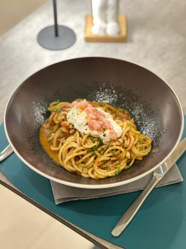 Piatto con gamberi impanati e tartare di manzo, guarnito con verdure e pois gialli.