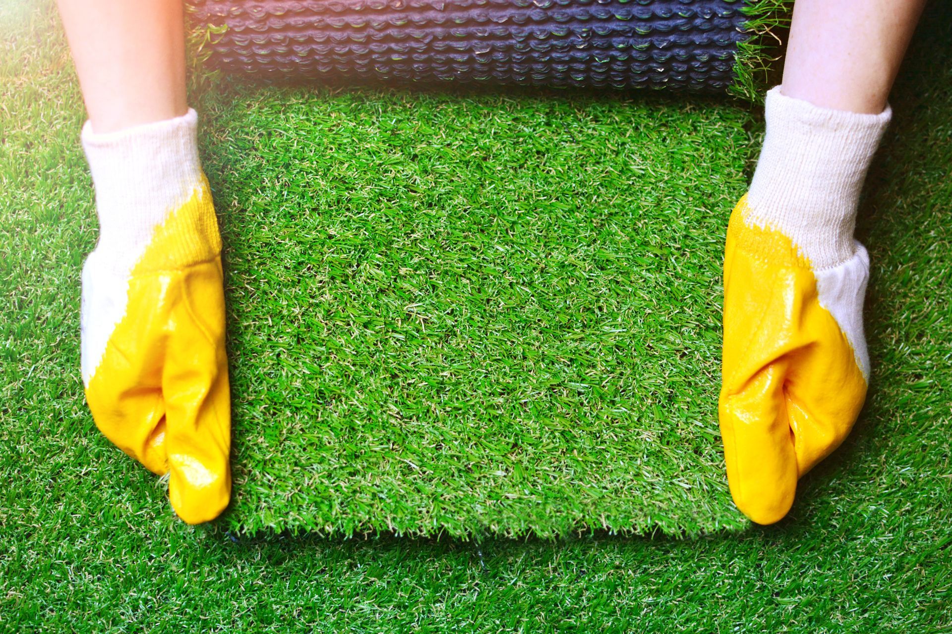 Close-up view of synthetic artificial grass material, showcasing its texture and vibrant green fibers.