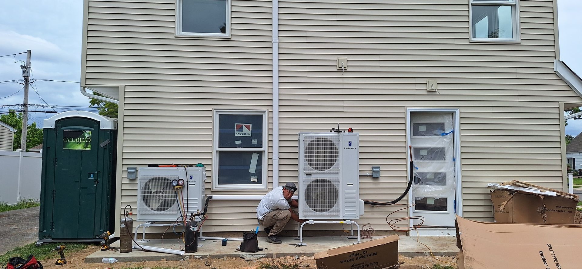 A person holding a baby up in the air indoors near a window, baby smiling.