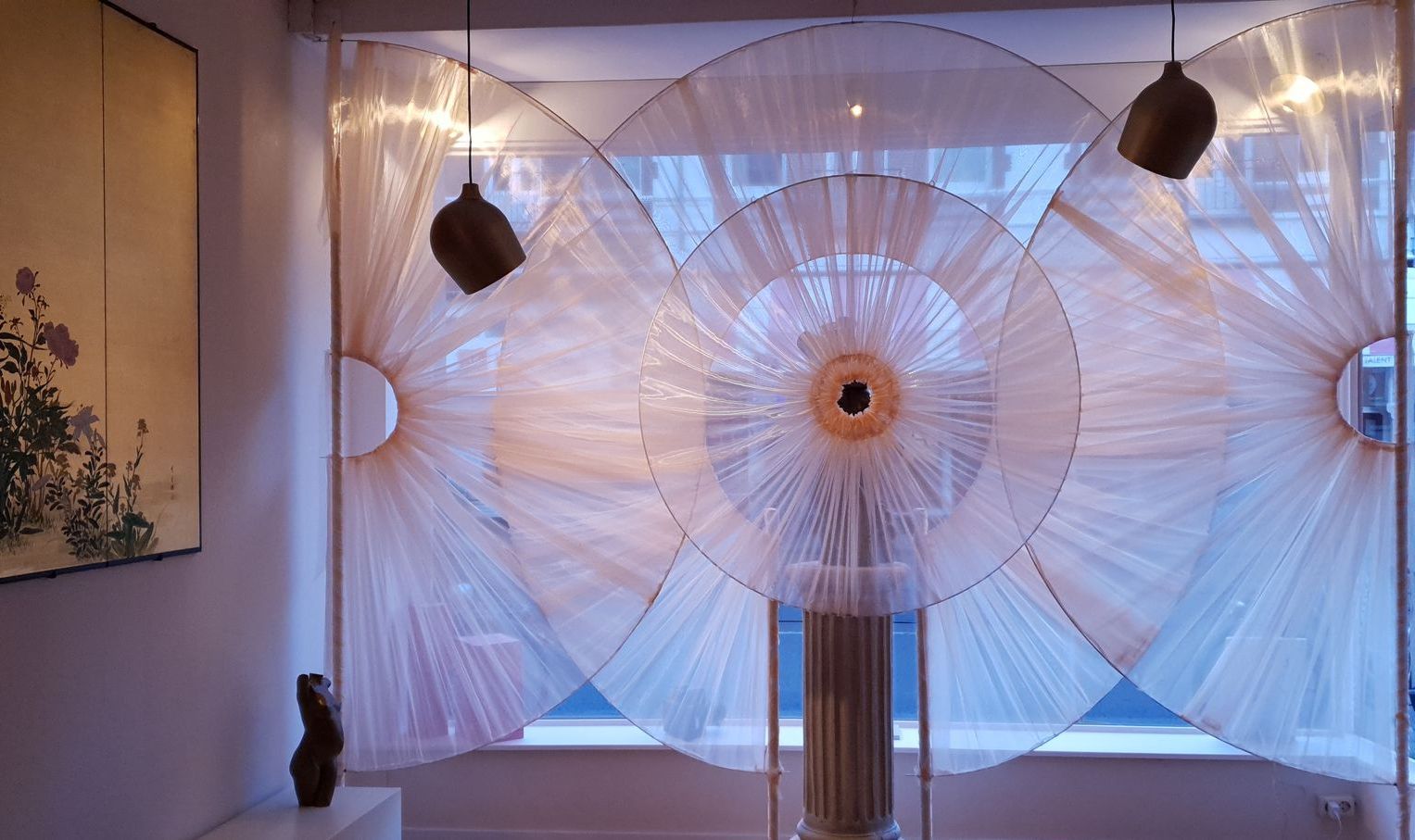 Raamkunstinstallatie met cirkelvormige ontwerpen in de kleuren beige en lichtroze . 3d sculptuur van torso.