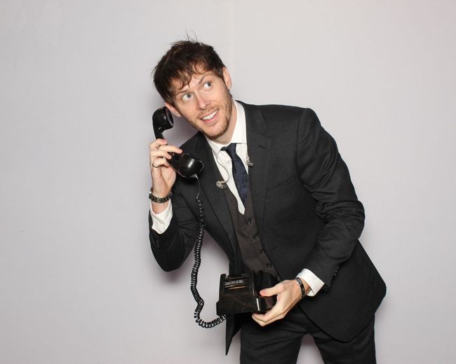 A man in a suit and tie is talking on a phone