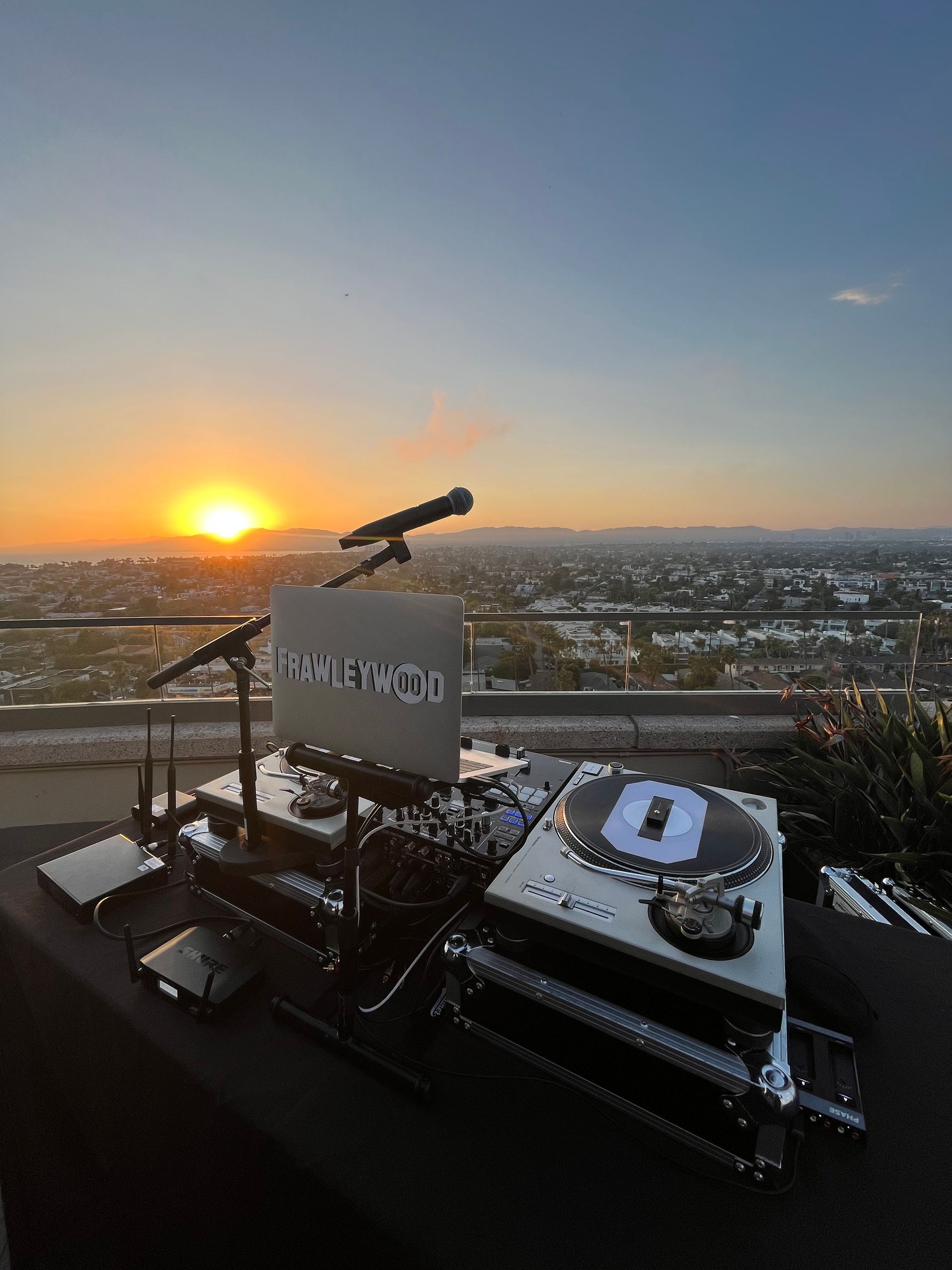A dj set is sitting on top of a table with a sunset in the background.