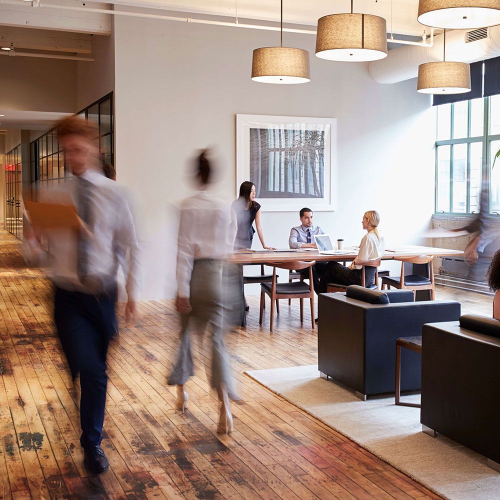 A sliding glass door with a white handle and a reflection of a house in the window.