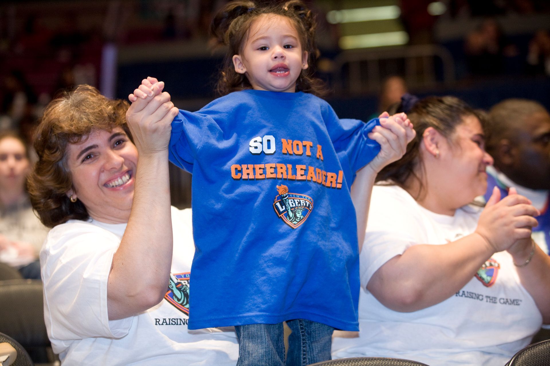 A little girl wearing a blue shirt that says 60 not a cheerleader