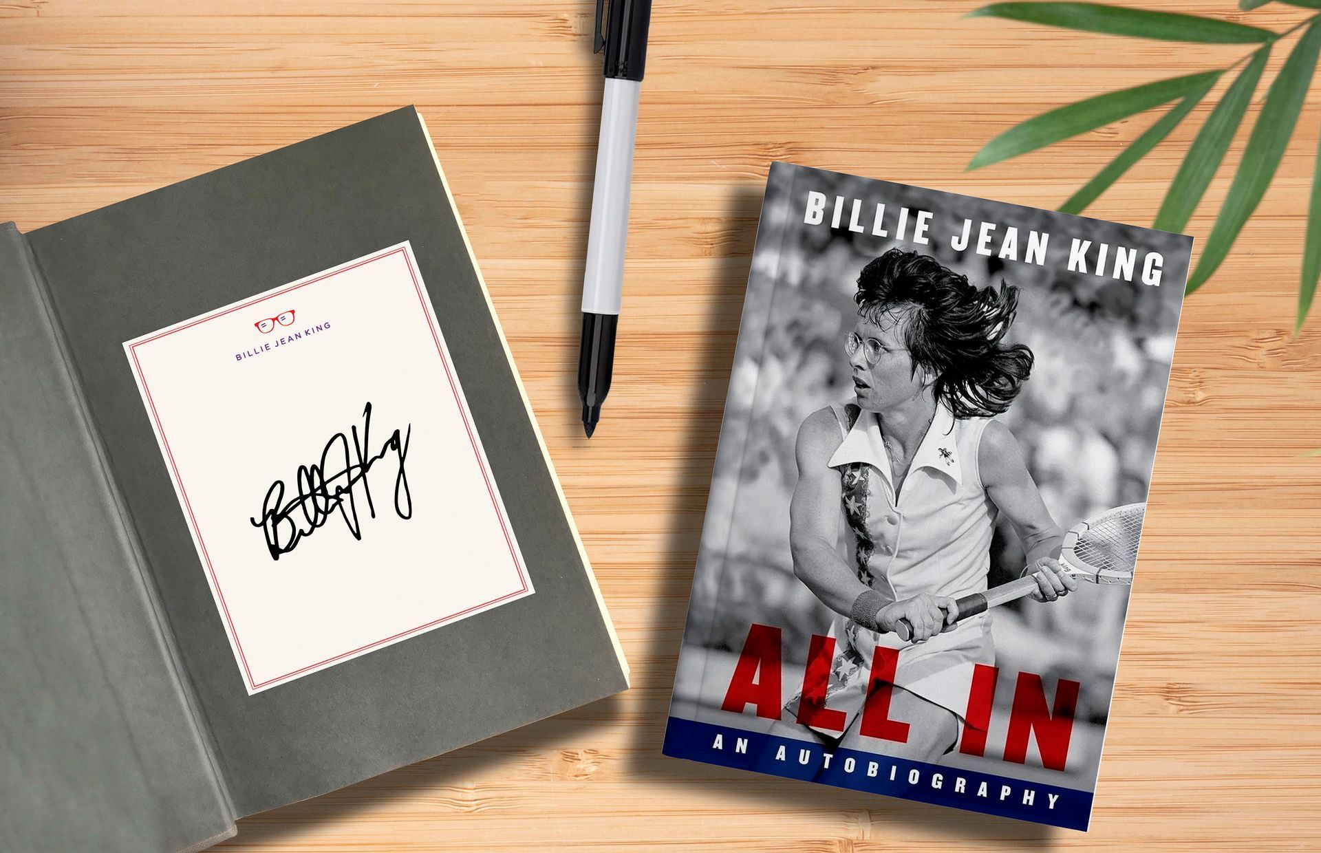 A book by billie jean king is on a wooden table