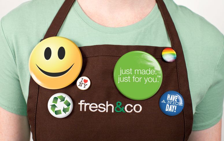 A person wearing an apron that says fresh & co