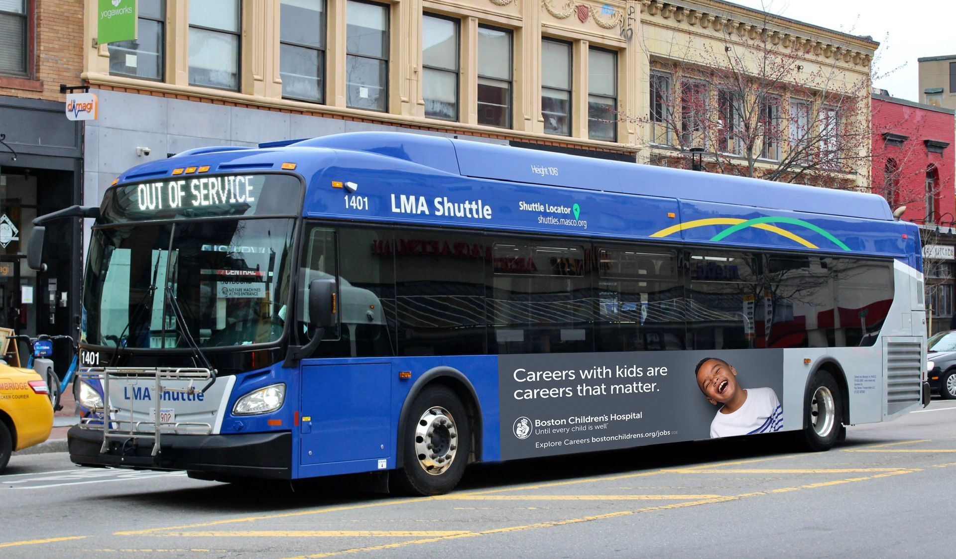 A blue bus that says out of service is driving down a city street.