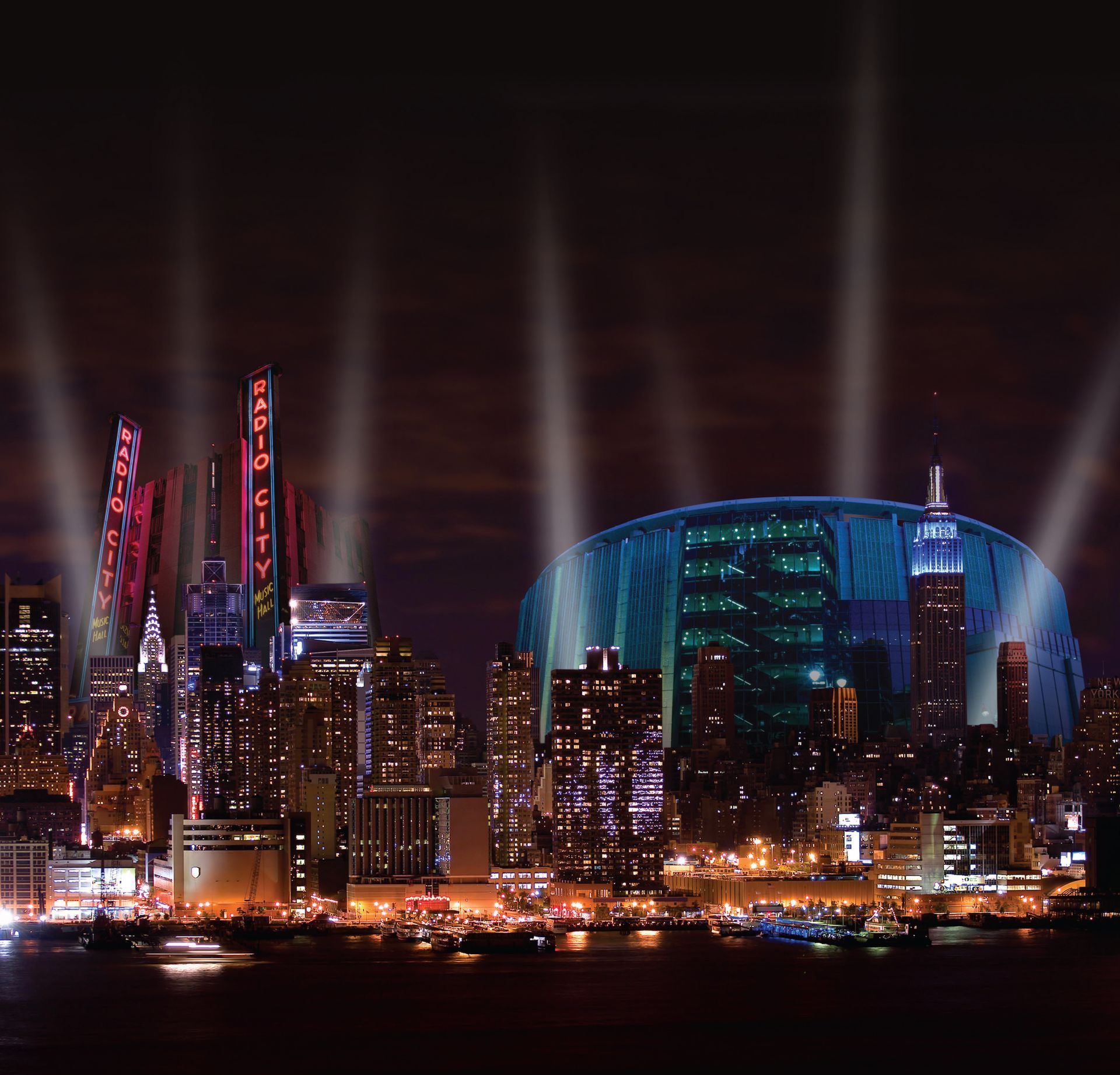 A city skyline at night with a stadium lit up