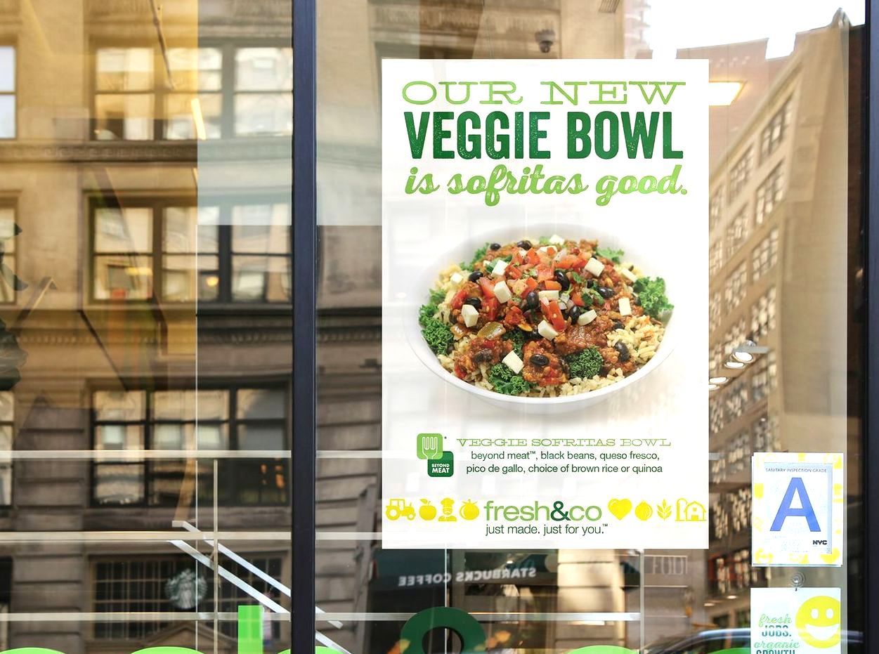 A poster in a window advertising a veggie bowl