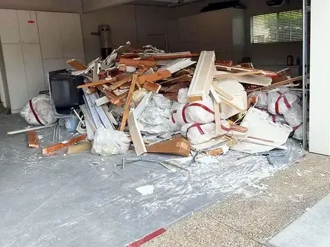 A garage filled with lots of boxes and a ladder.
