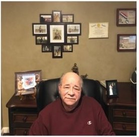 A man in a champion shirt sits in a chair