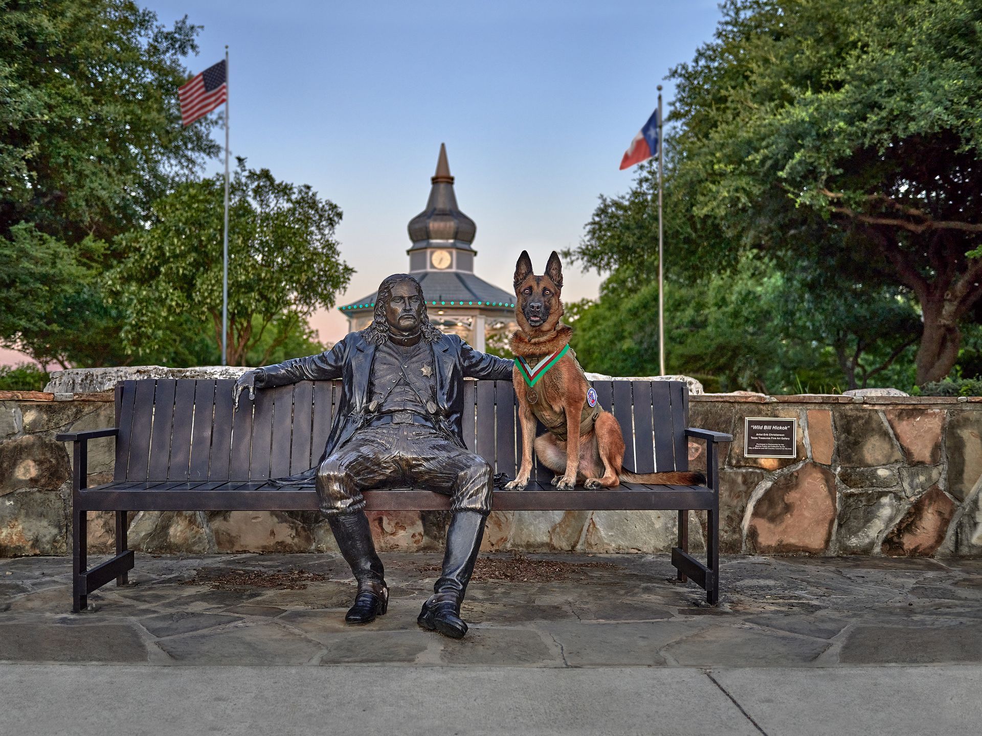 A statue of a man and a dog sitting on a bench