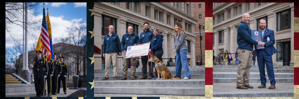 A group of people standing in front of a building holding a check and shaking hands.