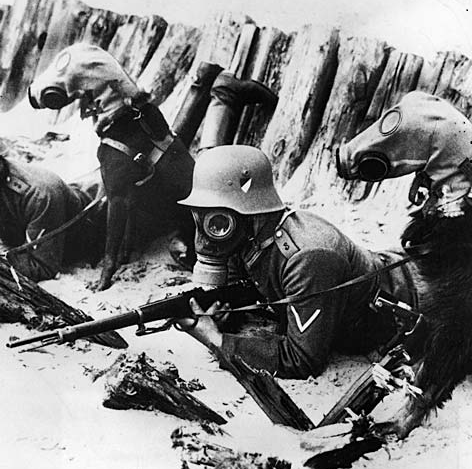 A black and white photo of soldiers wearing gas masks
