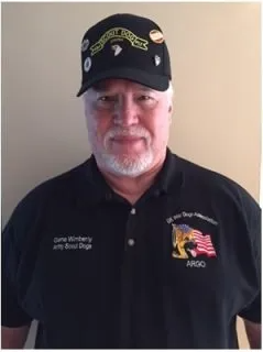 A man wearing a hat and a black shirt that says ngo