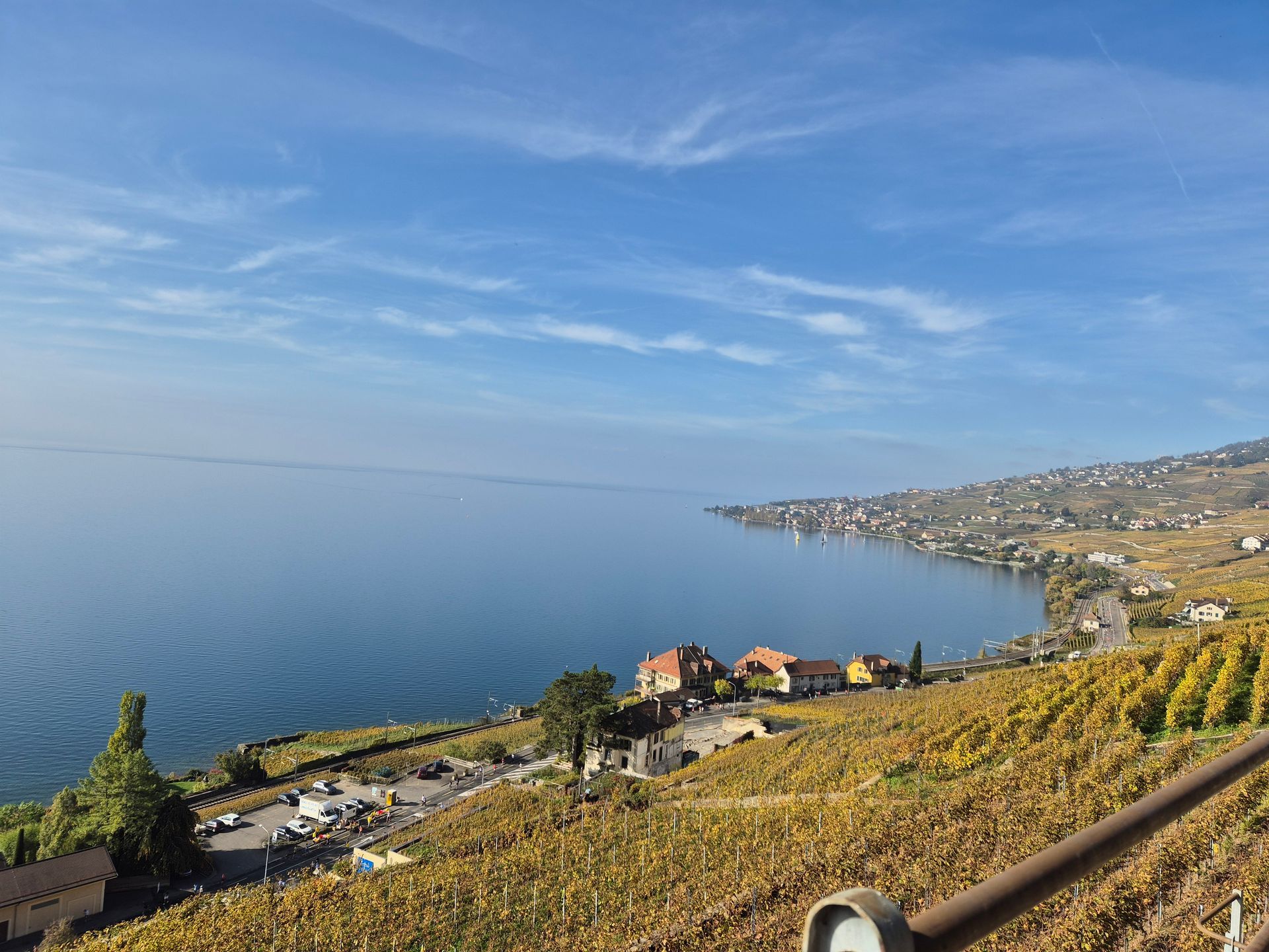 Une vue d'un lac depuis une falaise surplombant un vignoble.