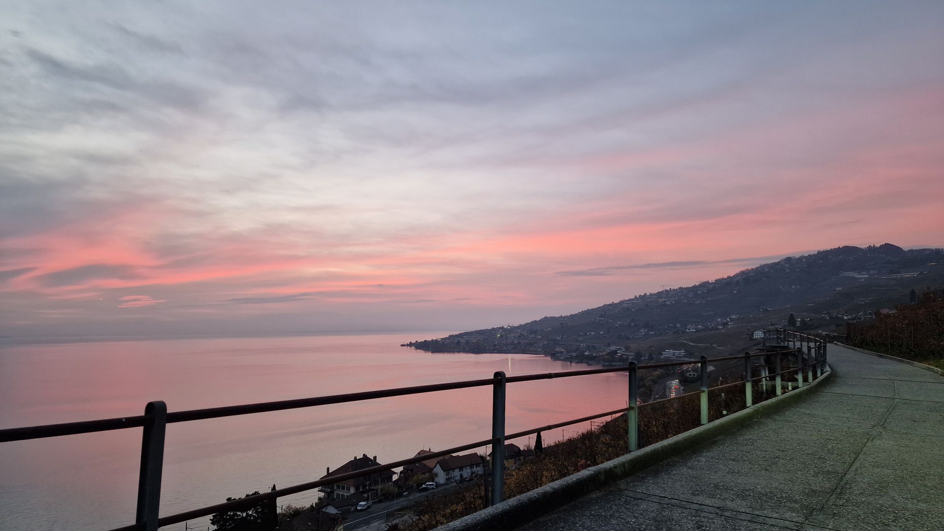 Un coucher de soleil sur un plan d'eau avec une clôture au premier plan