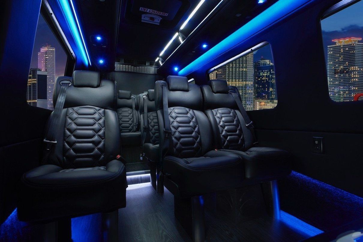 The inside of a van with lots of seats and blue lights.