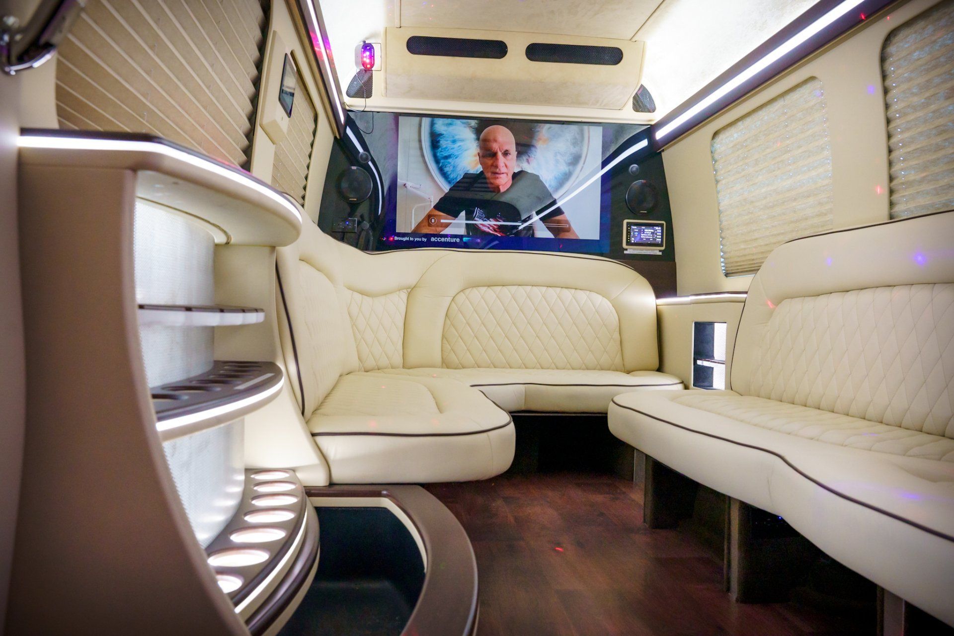 The inside of a van with a couch and a television.