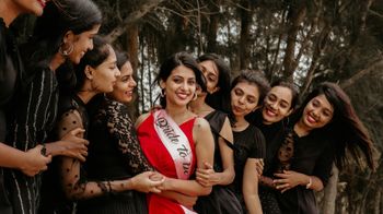 A group of women in black dresses are posing for a picture.