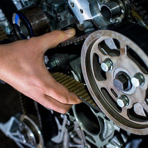A Person Is Fixing A Belt On A Motorcycle Engine — P & M Performance & Mechanical In Bungalow, QLD