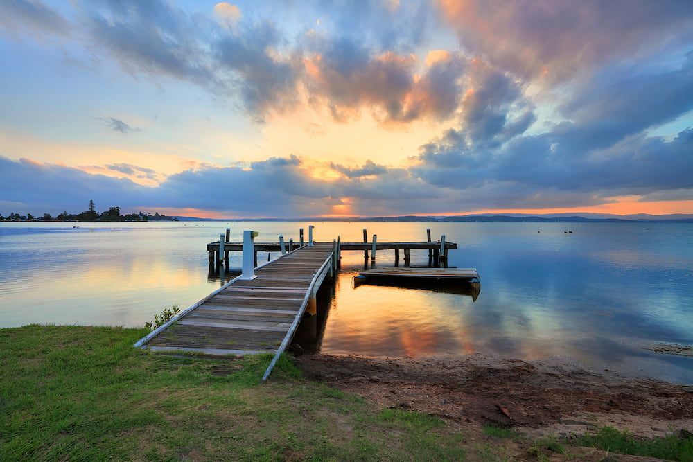 There Is A Dock In The Middle Of The Water At Sunset — Justin Drew Plumbing in Belmont, VIC