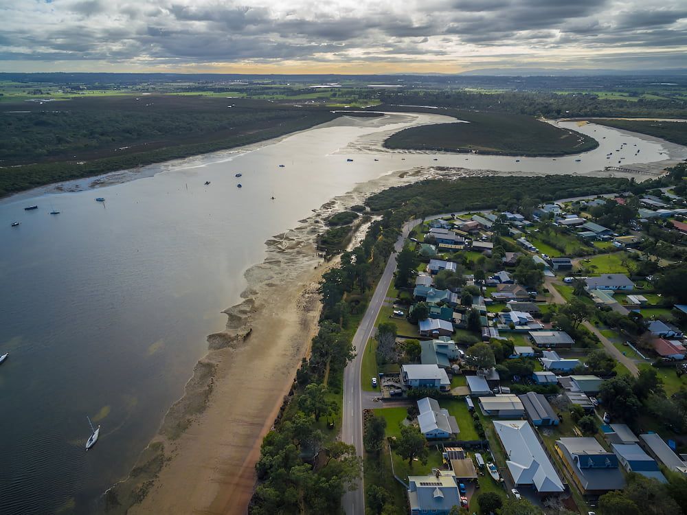 An Aerial View Of A River Surrounded By Houses And Trees — Justin Drew Plumbing in Armstrong Creek, VIC