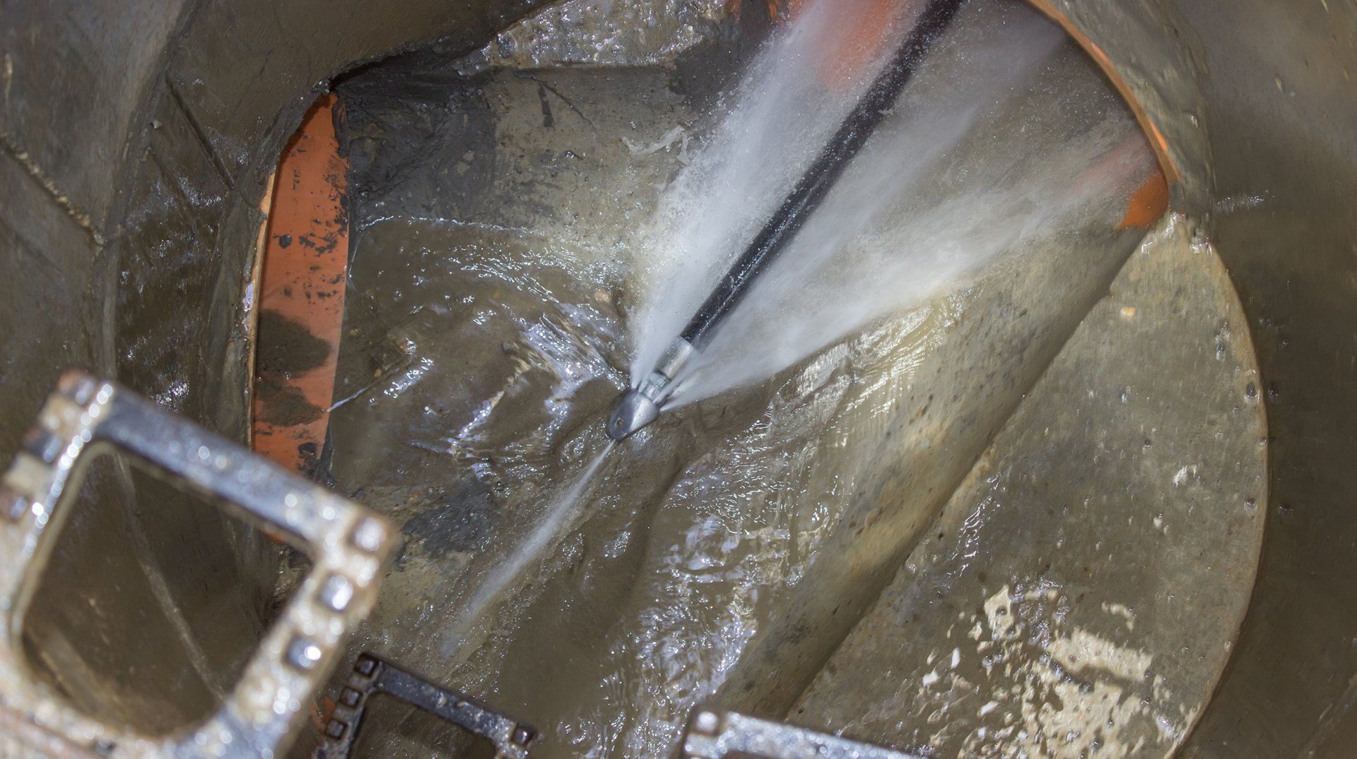 A close up of a stainless steel kitchen sink with water running from the faucet.