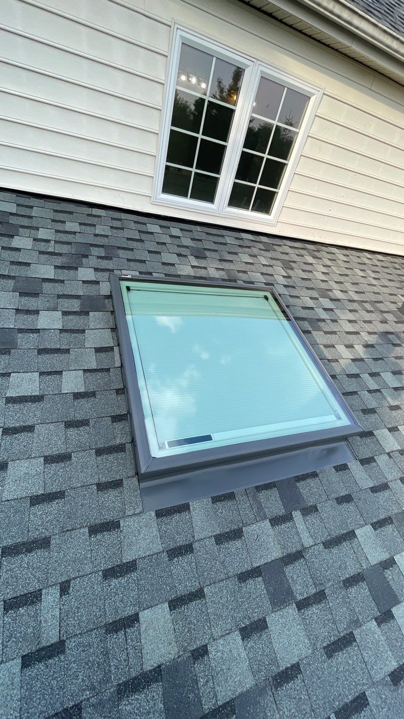 There is a skylight on the roof of a house.