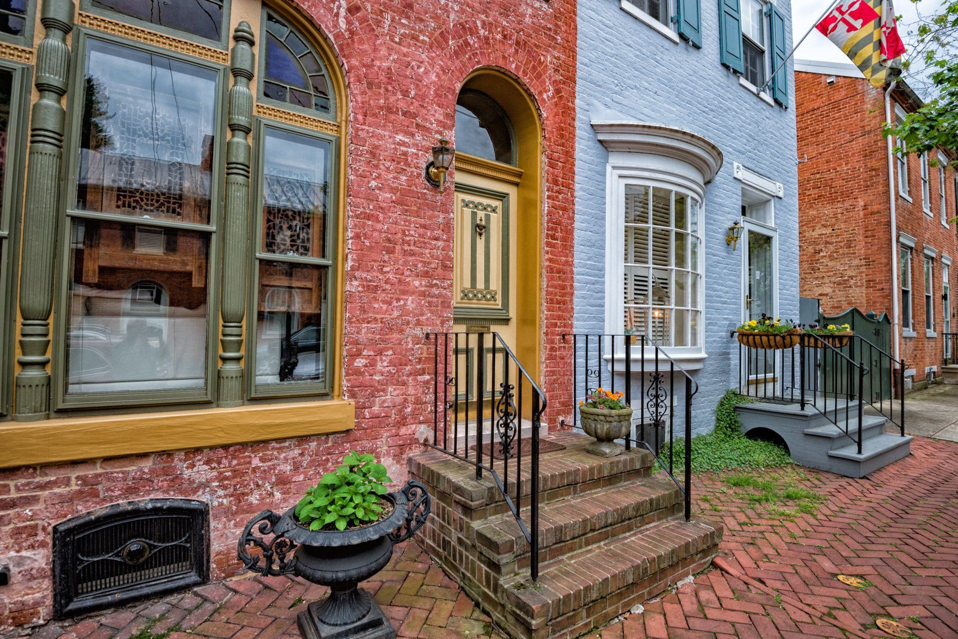 a red brick building with a yellow door and green windows