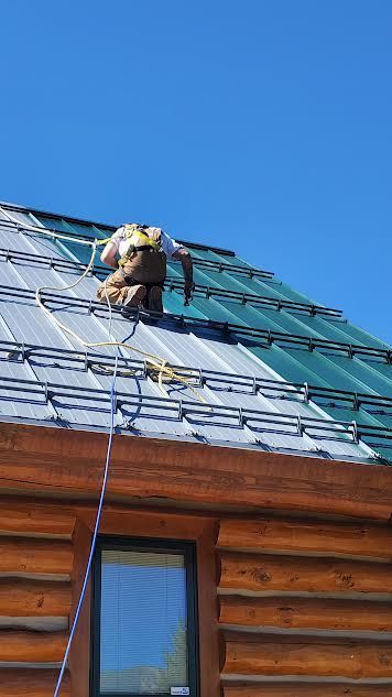 A person is painting a roof with a sprayer.