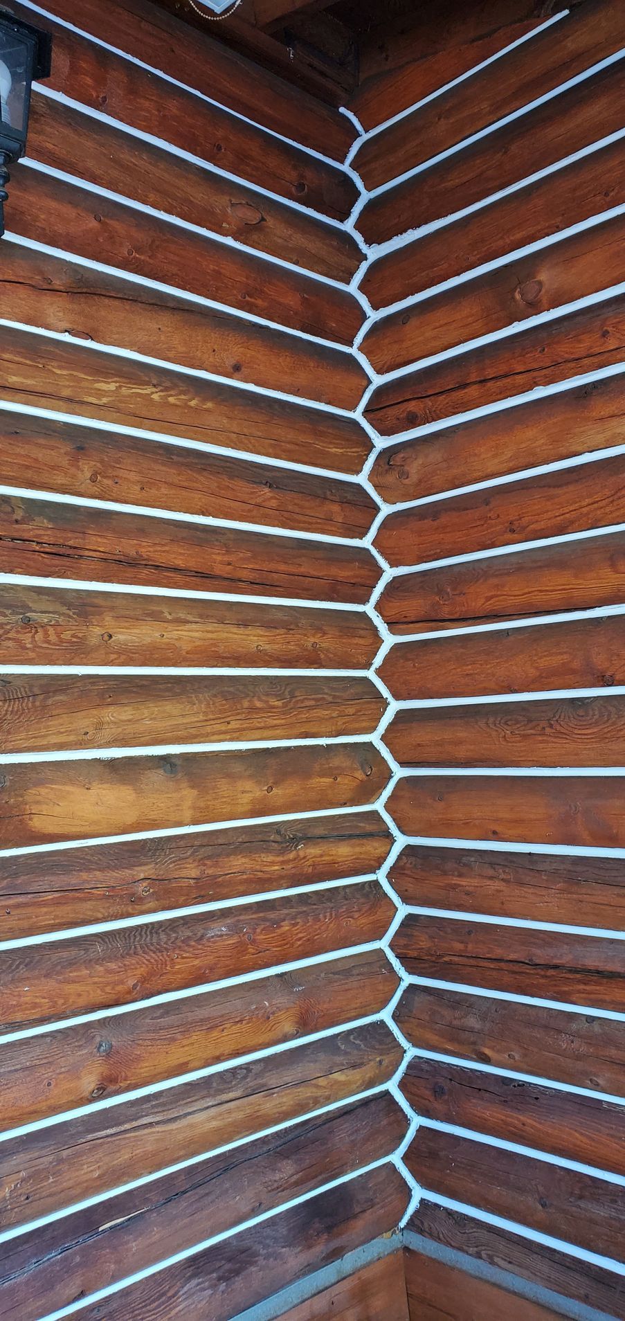 A close up of a wooden wall with white lines on it.