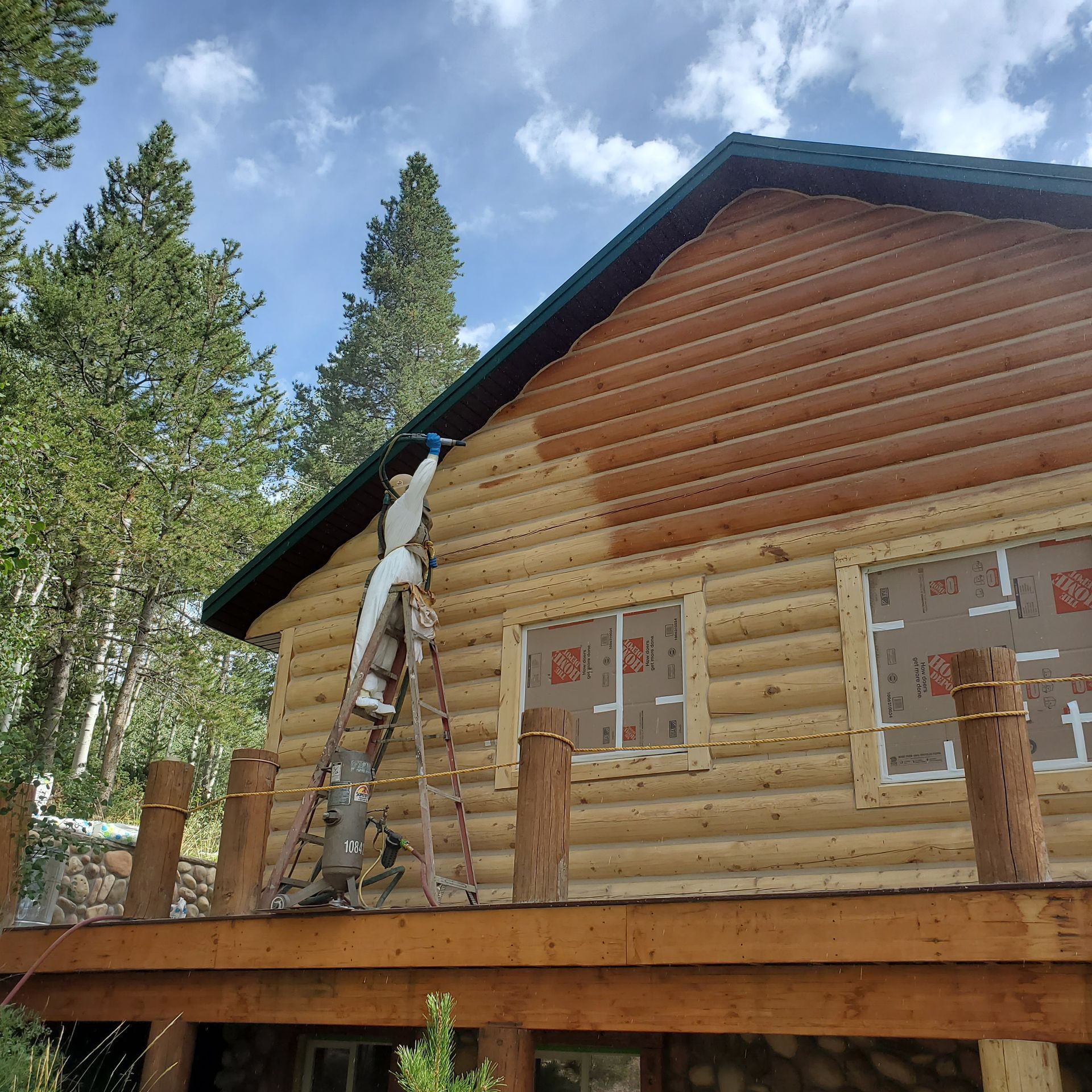 A man wearing a shirt that says verwin williams is cleaning a window