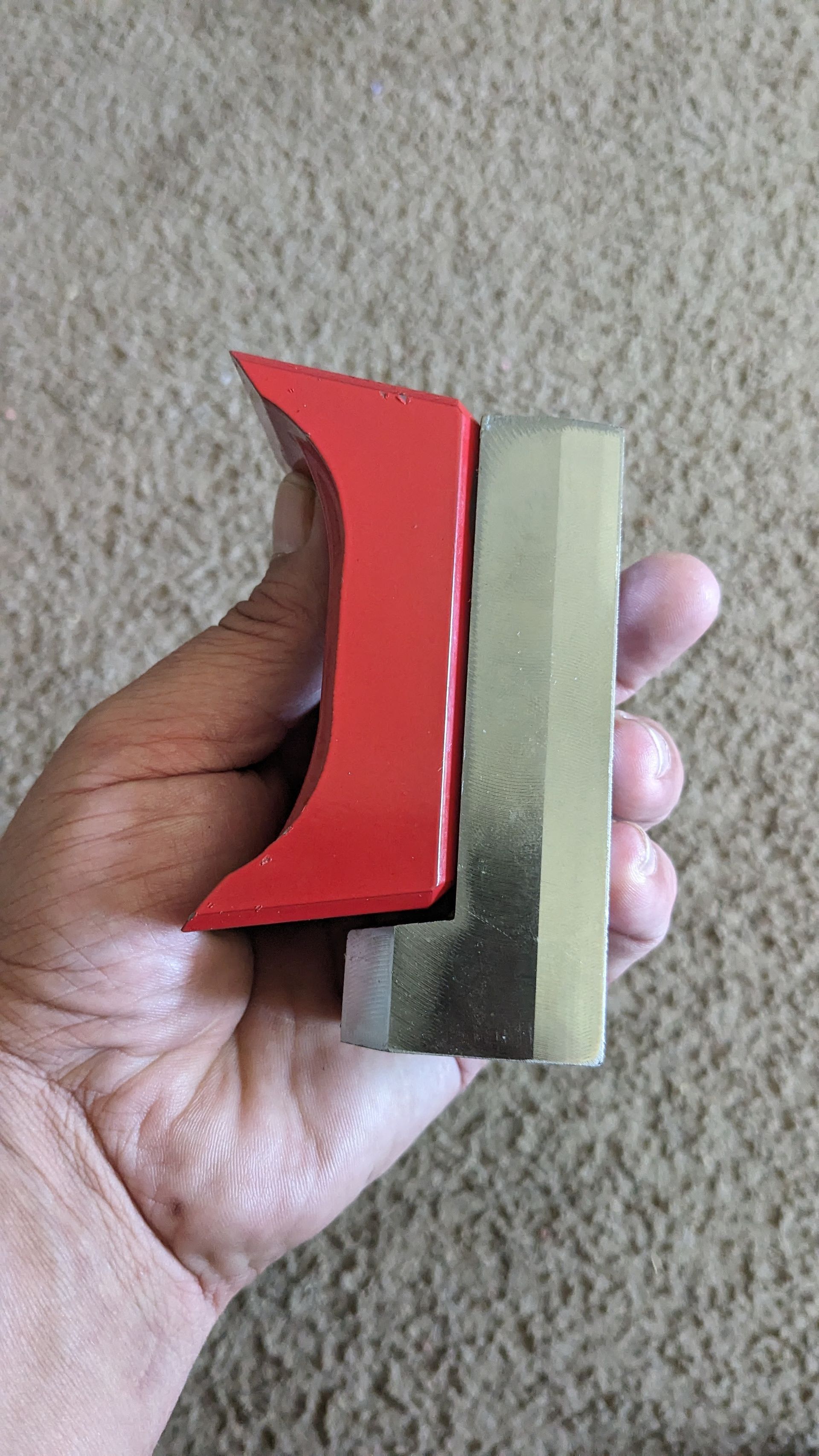 A person is holding a red object in their hand.