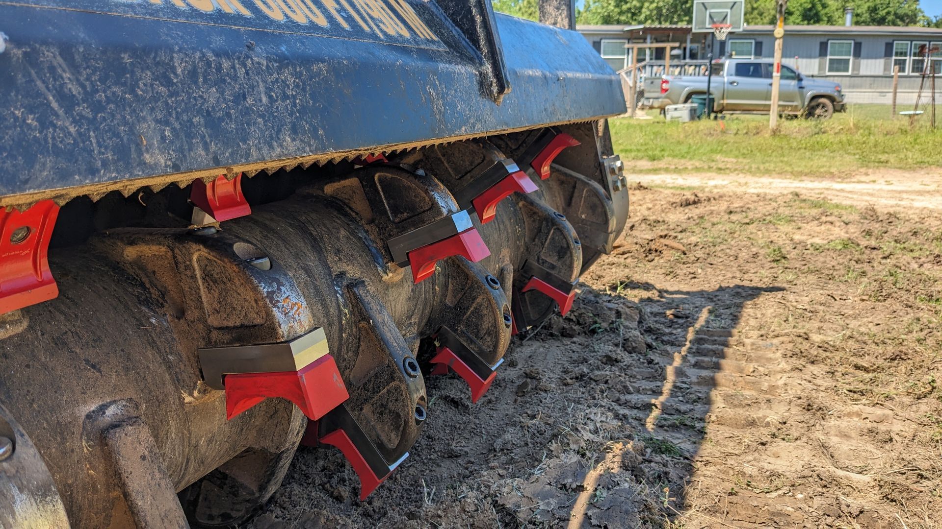 A tractor is sitting in the dirt in a field.