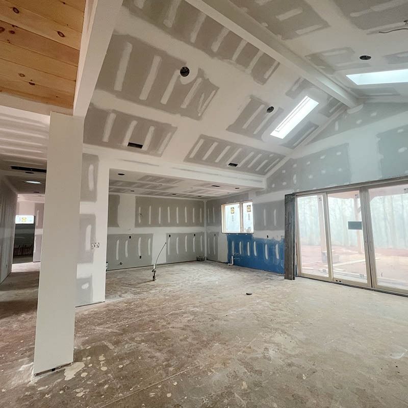 A large room with a lot of windows and drywall on the walls