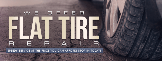 Flat tire advertisement, a deflated tire on asphalt with the text