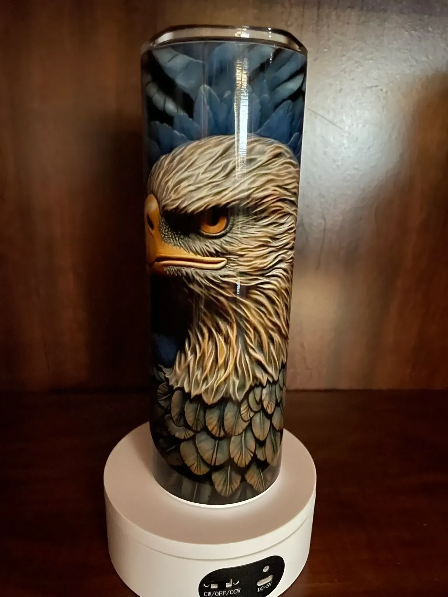 A tumbler with an eagle on it is sitting on a table.