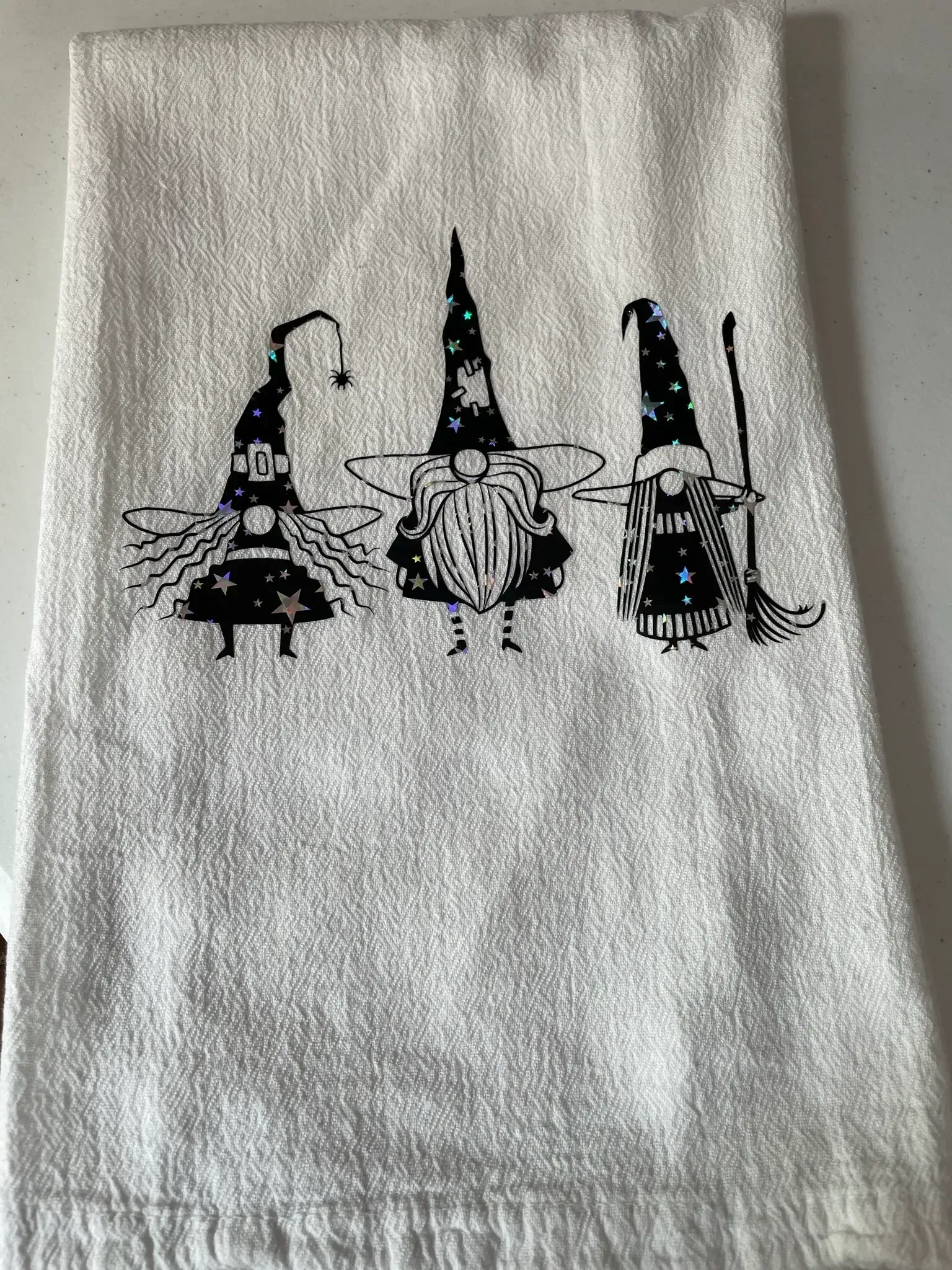 A white towel with three gnomes on it.