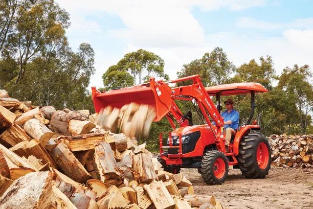 Tractor moving pieces of wood— Machinery Sells In Dorrigo, NSW