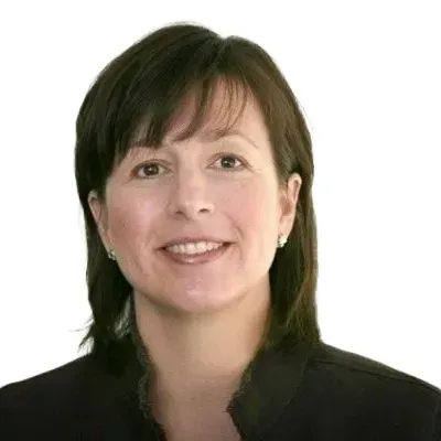 A woman with brown hair is smiling and wearing a black jacket.