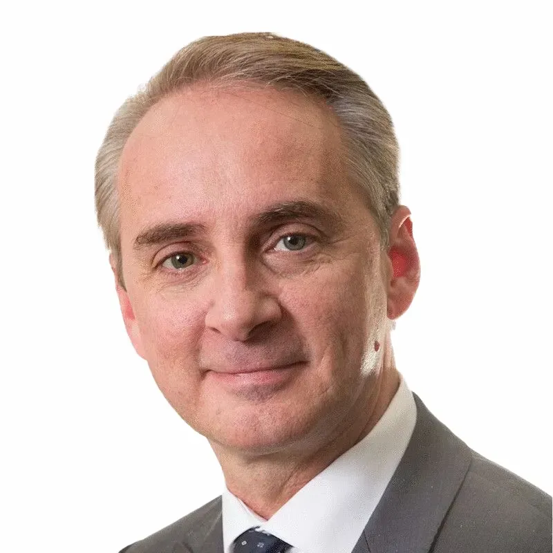 A man in a suit and tie is smiling for the camera