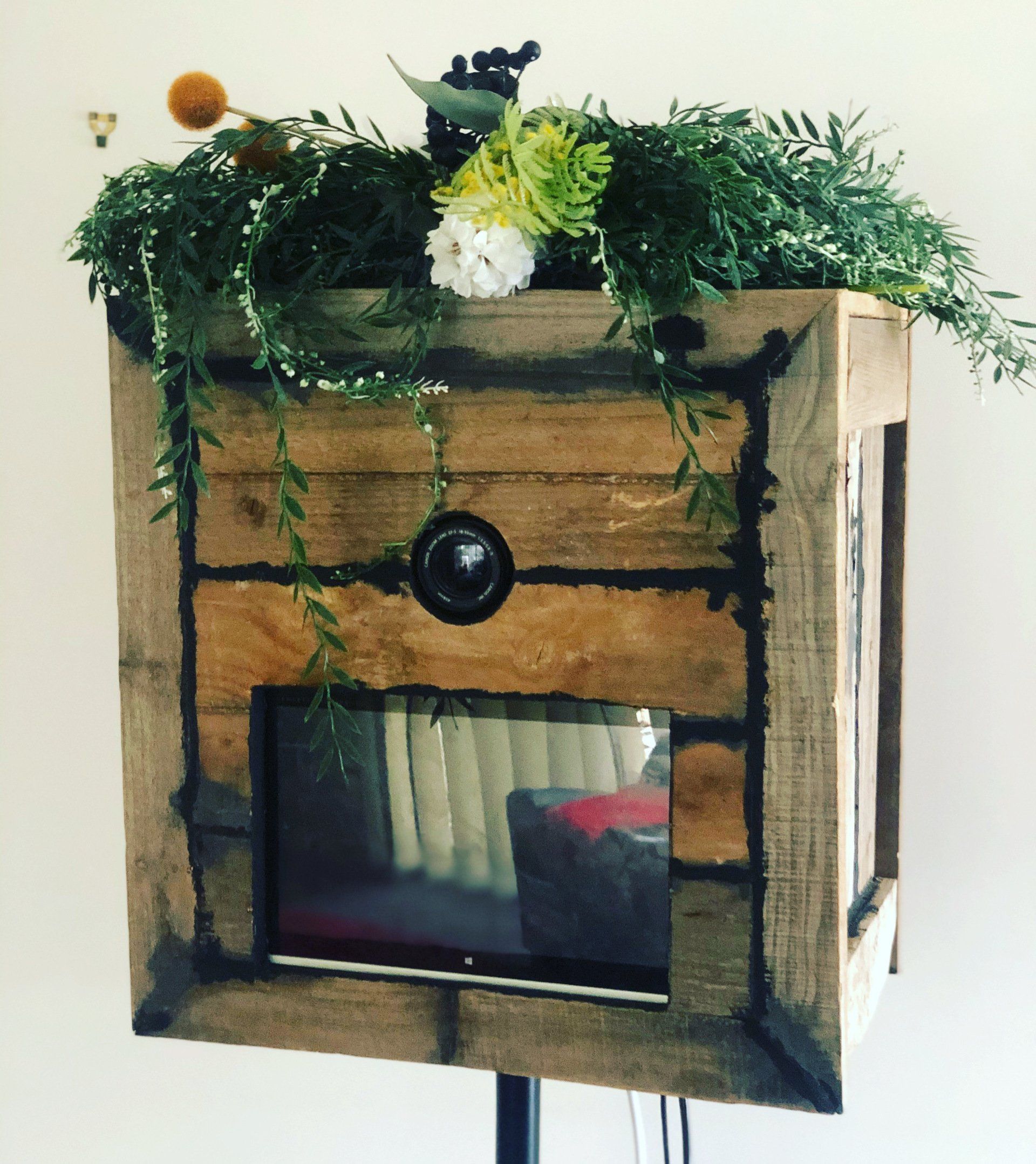 A rustic wooden box with flowers on top of it
